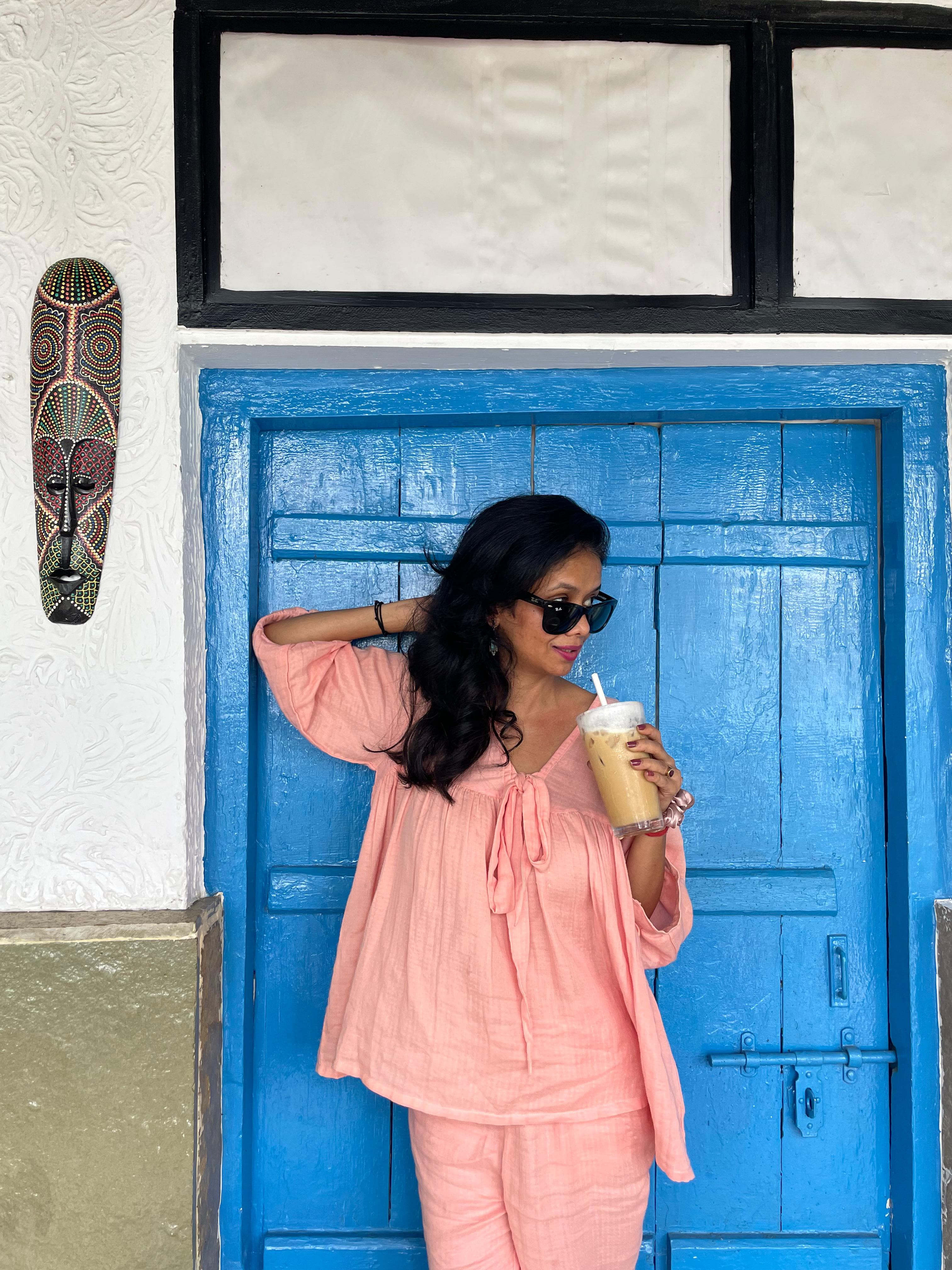A female customer wearing a Paizlie beige gold silk loungewear set, taking photo outdoors.