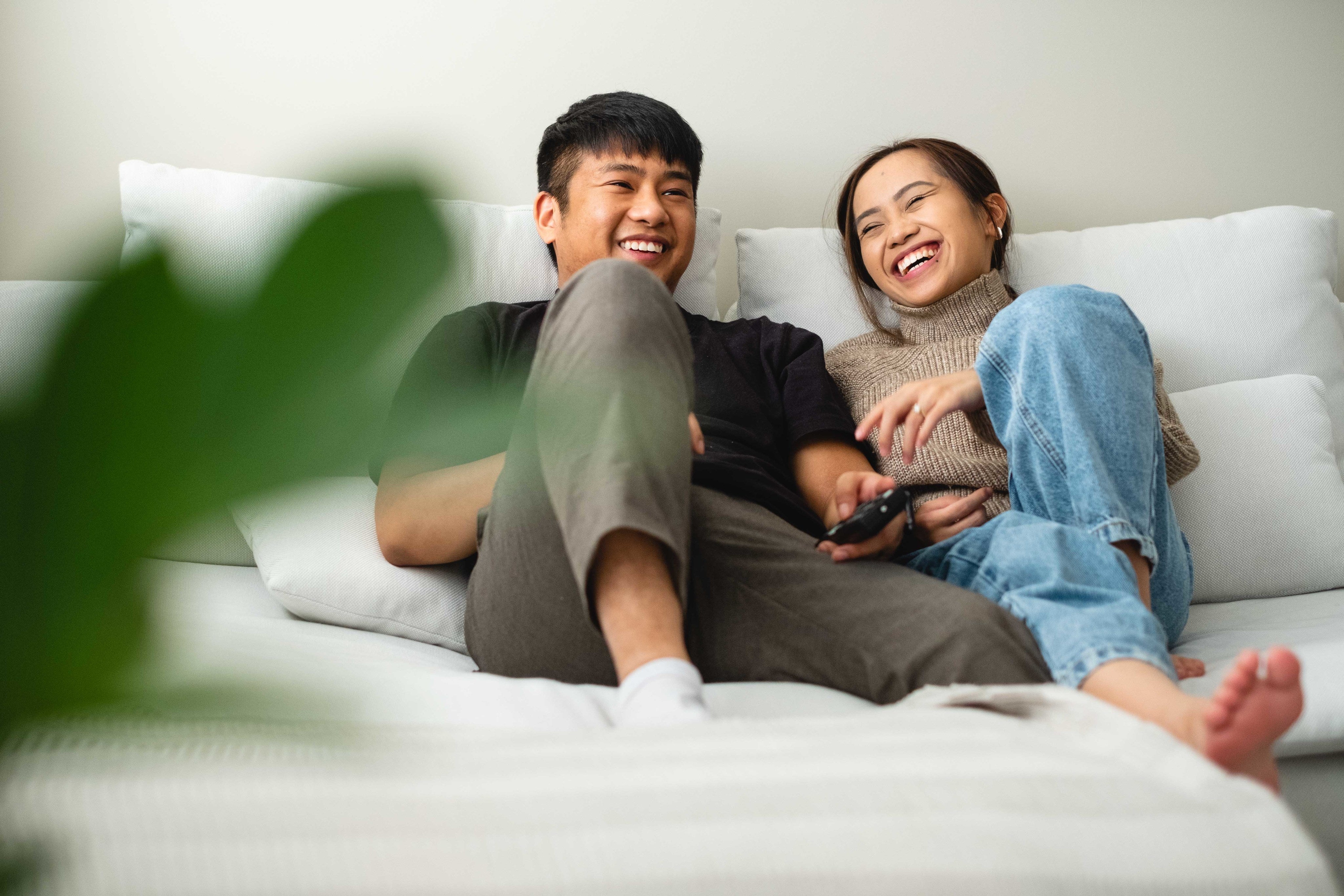 a-couple-laughing-and-relaxing-together-on-their-couch.jpg